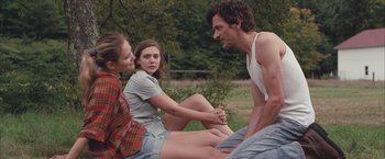 Movie still from “Martha Marcy May Marlene” (2011), directed by Sean Durkin – A man and two women sitting on the grass; Medium shot, Over the shoulder angle
