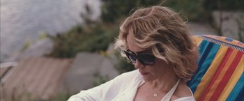 Movie still from “Martha Marcy May Marlene” (2011), directed by Sean Durkin – A person wearing a white shirt and sunglasses; Close Up shot, Low angle