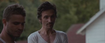 Movie still from “Martha Marcy May Marlene” (2011), directed by Sean Durkin – A person wearing a white t - shirt; Close Up shot, Low angle