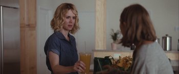 Movie still from “Martha Marcy May Marlene” (2011), directed by Sean Durkin – A woman holding a glass of orange juice in her hand; Medium shot, Over the shoulder angle