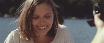 Movie still from “Martha Marcy May Marlene” (2011), directed by Sean Durkin – A person smiling with her eyes closed; Close Up shot, Over the shoulder angle