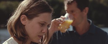 Movie still from “Martha Marcy May Marlene” (2011), directed by Sean Durkin – A man and a woman are drinking orange juice; Close Up shot, Over the shoulder angle