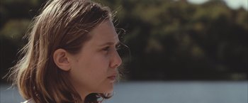 Movie still from “Martha Marcy May Marlene” (2011), directed by Sean Durkin – A person with long brown hair; Close Up shot, Over the shoulder angle