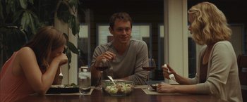 Movie still from “Martha Marcy May Marlene” (2011), directed by Sean Durkin – A man sitting at a table with a plate of food; Medium shot, Over the shoulder angle