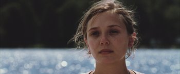 Movie still from “Martha Marcy May Marlene” (2011), directed by Sean Durkin – A young woman's face in front of a body of water; Close Up shot, Over the shoulder angle