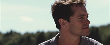Movie still from “Martha Marcy May Marlene” (2011), directed by Sean Durkin – A man's face with trees in the background; Close Up shot, Low angle
