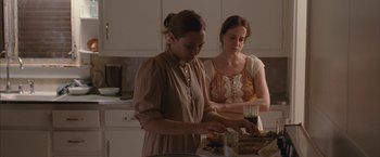 Movie still from “Martha Marcy May Marlene” (2011), directed by Sean Durkin – Two women standing in a kitchen preparing food; Medium shot, Over the shoulder angle