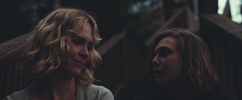 Movie still from “Martha Marcy May Marlene” (2011), directed by Sean Durkin – Two women sitting next to each other in a forest; Close Up shot, Over the shoulder angle