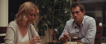 Movie still from “Martha Marcy May Marlene” (2011), directed by Sean Durkin – A man and a woman sitting at a table with a glass of wine; Medium shot, Over the shoulder angle