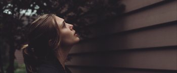Movie still from “Martha Marcy May Marlene” (2011), directed by Sean Durkin – A woman looking up into the air with her eyes closed; Close Up shot, Low angle