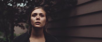 Movie still from “Martha Marcy May Marlene” (2011), directed by Sean Durkin – A young woman is looking into the distance; Close Up shot, Low angle