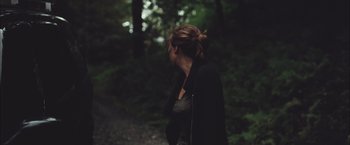 Movie still from “Martha Marcy May Marlene” (2011), directed by Sean Durkin – A woman walking down a path in the woods; Close Up shot, Over the shoulder angle