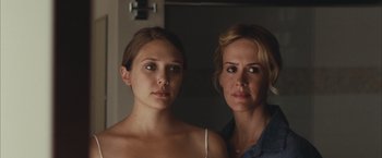 Two women standing next to each other in front of a mirror