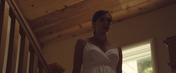 Movie still from “Martha Marcy May Marlene” (2011), directed by Sean Durkin – A woman in a white dress standing in front of a window; Medium shot, Low angle