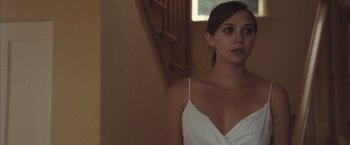 Movie still from “Martha Marcy May Marlene” (2011), directed by Sean Durkin – A woman in a white dress standing next to a staircase; Close Up shot, Low angle