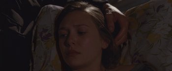 Movie still from “Martha Marcy May Marlene” (2011), directed by Sean Durkin – A woman is getting her hair combed by a man; Close Up shot, High angle