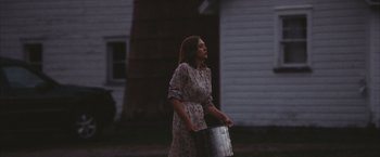 Movie still from “Martha Marcy May Marlene” (2011), directed by Sean Durkin – A woman holding a large metal bucket in her hands; Medium shot, Low angle