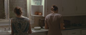 Movie still from “Martha Marcy May Marlene” (2011), directed by Sean Durkin – Two women in a kitchen preparing a meal; Medium shot, Over the shoulder angle