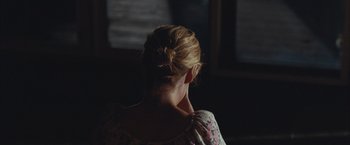 Movie still from “Martha Marcy May Marlene” (2011), directed by Sean Durkin – A woman with her hair in a low bun; Close Up shot, Over the shoulder angle
