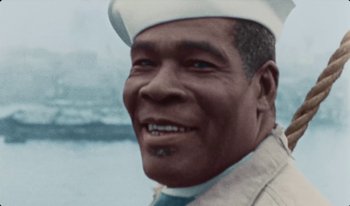 Movie still from “Martin Eden” (2019), directed by Pietro Marcello – An older man wearing a sailor's hat smiling for the camera; Close Up shot, High angle