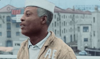 Movie still from “Martin Eden” (2019), directed by Pietro Marcello – An older man wearing a sailor's hat and jacket; Close Up shot, High angle