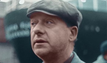 Movie still from “Martin Eden” (2019), directed by Pietro Marcello – An older man wearing a hat and looking to his left; Close Up shot, Low angle