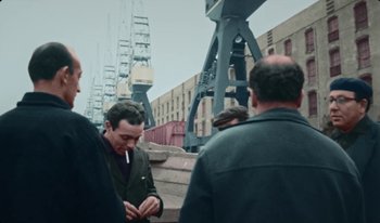 Movie still from “Martin Eden” (2019), directed by Pietro Marcello – A group of men standing next to each other on a bridge; Medium shot, High angle