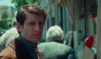 Movie still from “Martin Eden” (2019), directed by Pietro Marcello – A person wearing a suit and tie; Close Up shot, Low angle