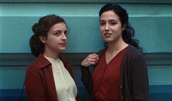 Movie still from “Martin Eden” (2019), directed by Pietro Marcello – Two women standing next to each other in front of a blue wall; Close Up shot, Low angle
