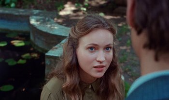Movie still from “Martin Eden” (2019), directed by Pietro Marcello – A woman with long brown hair wearing a green shirt; Close Up shot, Over the shoulder angle