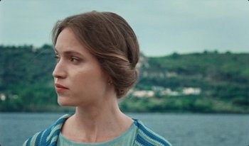 Movie still from “Martin Eden” (2019), directed by Pietro Marcello – A young woman with brown hair wearing a blue sweater; Close Up shot, Over the shoulder angle