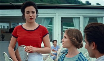 Movie still from “Martin Eden” (2019), directed by Pietro Marcello – Two young women standing next to each other on a porch; Medium shot, Over the shoulder angle