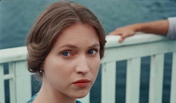 Movie still from “Martin Eden” (2019), directed by Pietro Marcello – A young woman with blue eyes stares into the camera; Close Up shot, High angle