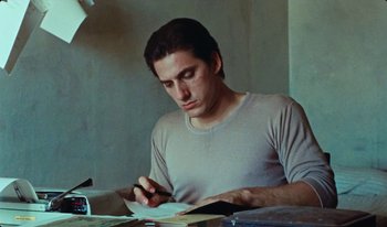 Movie still from “Martin Eden” (2019), directed by Pietro Marcello – A man writing on a piece of paper at a desk; Close Up shot, Low angle