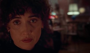 Movie still from “Martin Eden” (2019), directed by Pietro Marcello – A woman's face in a dark room; Close Up shot, Over the shoulder angle