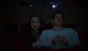 Movie still from “Martin Eden” (2019), directed by Pietro Marcello – A man and a woman sitting in a movie theater; Medium shot, Low angle