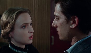 Movie still from “Martin Eden” (2019), directed by Pietro Marcello – A man and a woman face to face in front of a door; Close Up shot, Over the shoulder angle
