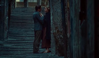 Movie still from “Martin Eden” (2019), directed by Pietro Marcello – A man and a woman standing next to each other on some steps; Wide shot, Low angle