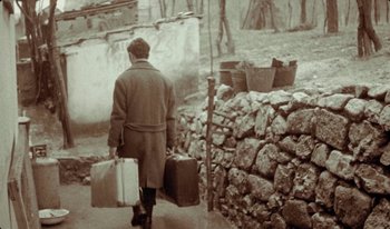 Movie still from “Martin Eden” (2019), directed by Pietro Marcello – An old photo of a man walking down the street carrying luggage; Wide shot, Low angle