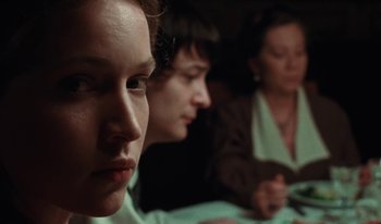 Movie still from “Martin Eden” (2019), directed by Pietro Marcello – A group of people sitting in a room together; Close Up shot, Over the shoulder angle