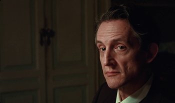 Movie still from “Martin Eden” (2019), directed by Pietro Marcello – A person wearing a suit and tie; Close Up shot, Low angle