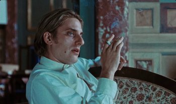 Movie still from “Martin Eden” (2019), directed by Pietro Marcello – A man sitting down with a cigarette in his mouth; Close Up shot, Low angle