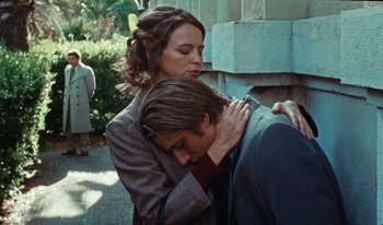 Movie still from “Martin Eden” (2019), directed by Pietro Marcello – A man and a woman hugging on the sidewalk; Medium shot, Low angle