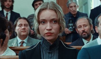 Movie still from “Martin Eden” (2019), directed by Pietro Marcello – A woman in a crowd of people in front of a camera; Close Up shot, Low angle
