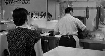 Movie still from “Marty” (1955), directed by Delbert Mann – A man and a woman are in a kitchen; Medium shot, Over the shoulder angle