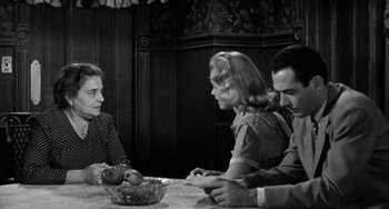 Movie still from “Marty” (1955), directed by Delbert Mann – A group of people sitting around a table; Medium shot, Over the shoulder angle