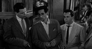 Movie still from “Marty” (1955), directed by Delbert Mann – A group of men standing next to each other on a train; Medium shot, High angle