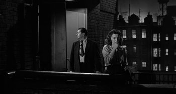 Movie still from “Marty” (1955), directed by Delbert Mann – A man and a woman standing next to each other in front of a building; Medium shot, Low angle