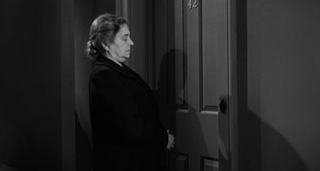 Movie still from “Marty” (1955), directed by Delbert Mann – An older woman standing in front of a door; Medium shot, Over the shoulder angle