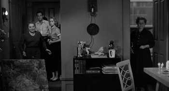 Movie still from “Marty” (1955), directed by Delbert Mann – A black - and - white photo of people in a living room; Medium shot, High angle